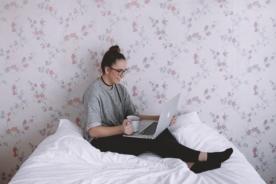 Vorschaubild (Frau mit Laptop zuhause auf dem Bett) vom MANEMO Seminar "Remote Leadership - Was wir brauchen, damit Führung auf Distanz gelingt..." – mit Wiebke Reissig (MANEMO eG)